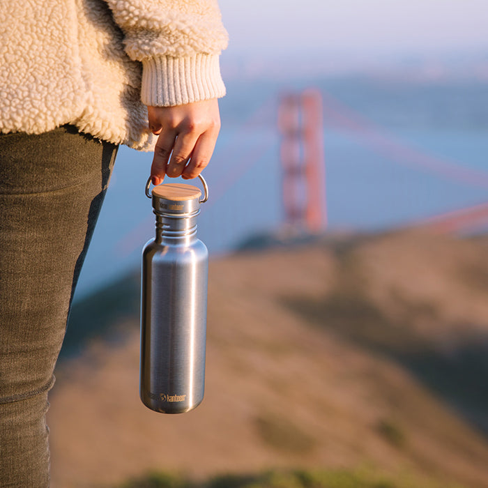 27oz-reflect-with-bamboo-cap-g4 K27SSLRF-BS-BAMBOO_reflect_bottle_bridge_lifestyle.jpg